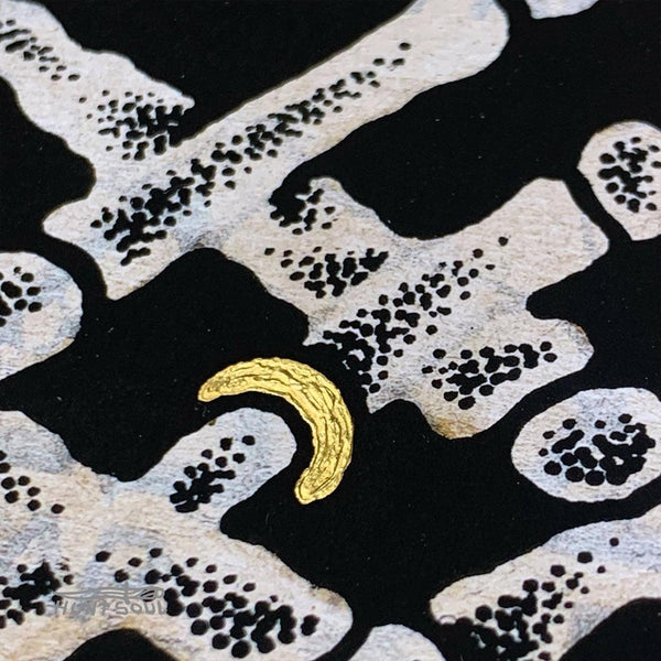 Close-up of printed artwork showing surreal details and skeletal imagery
